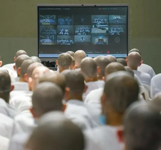 El juicio masivo, inició el lunes, pero no se dio acceso a los medios hasta el día siguiente, se celebra de forma virtual mediante una conexión en vivo con las celdas de los pandilleros, a los que se acusa de más de 47 mil delitos entre 2012 y ‌2022