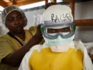 Una trabajadora sanitaria se coloca el equipo de protección individual (EPI) antes de entrar en un centro de tratamiento del ébola