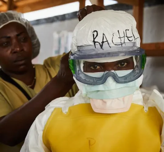 Una trabajadora sanitaria se coloca el equipo de protección individual (EPI) antes de entrar en un centro de tratamiento del ébola