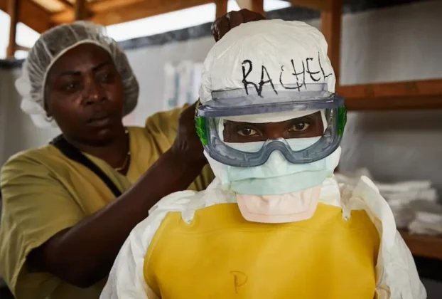 Una trabajadora sanitaria se coloca el equipo de protección individual (EPI) antes de entrar en un centro de tratamiento del ébola