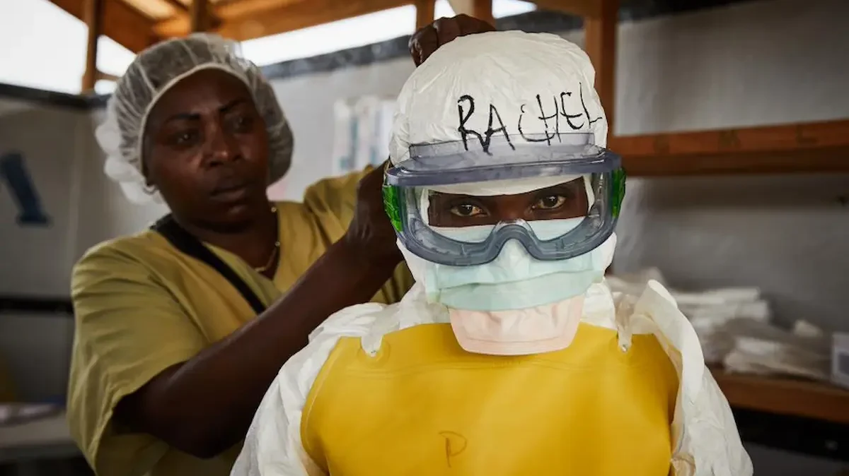 Una trabajadora sanitaria se coloca el equipo de protección individual (EPI) antes de entrar en un centro de tratamiento del ébola