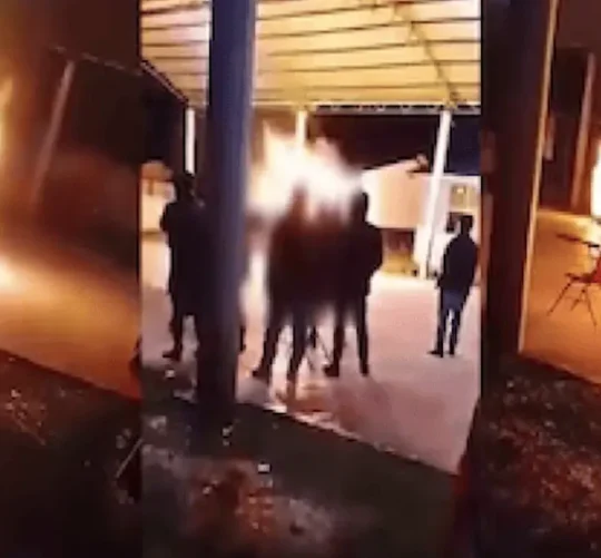 Videos difundidos en redes sociales muestran a varias personas reunidas mientras una de las víctimas, envuelta en llamas, intenta desplazarse por el lugar.